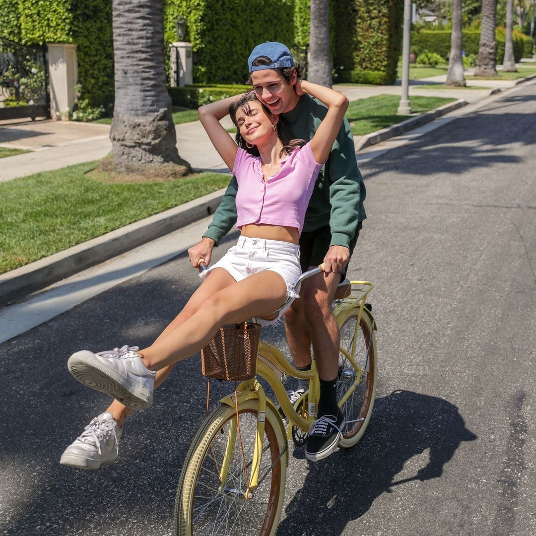 David Dobrik and Charlotte D'Alessio posing on a bicycle.