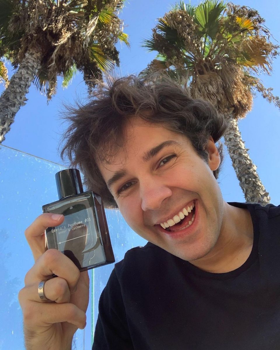 David Dobrik posing with his perfume. 