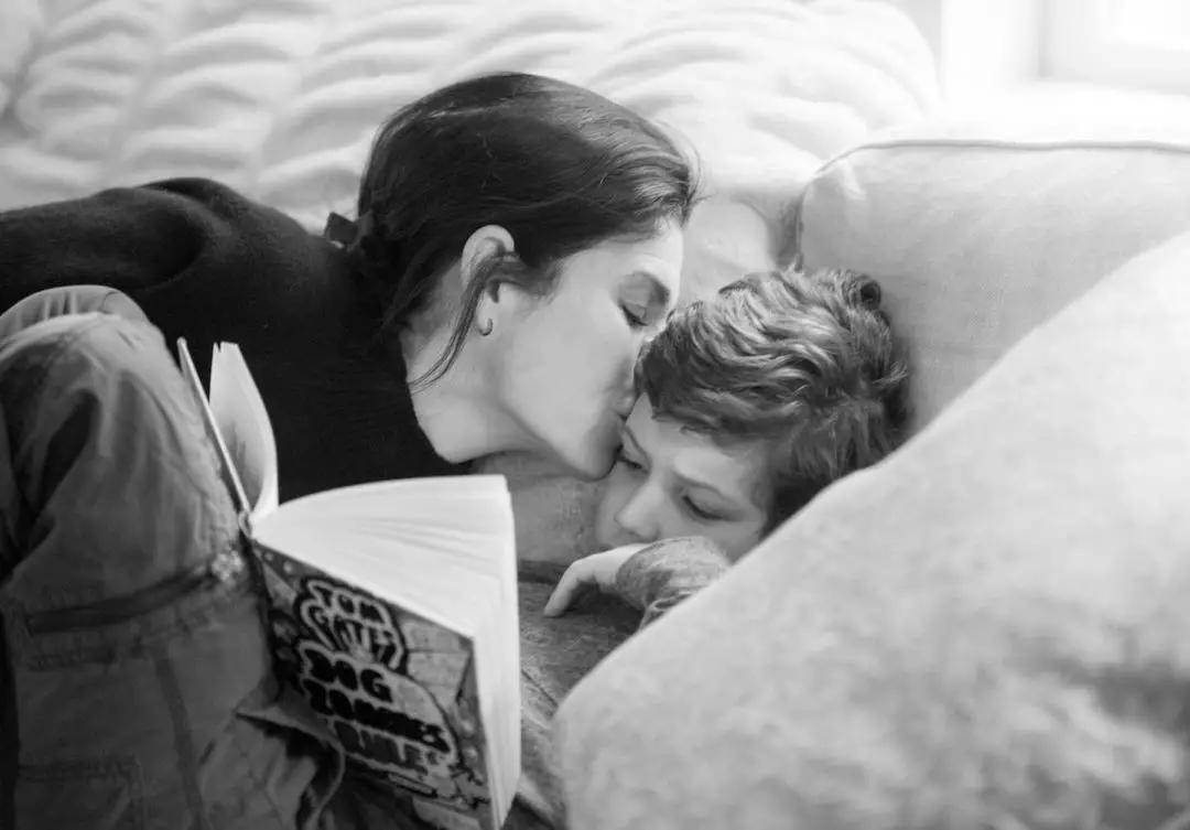 Julianna Margulies kissing her son Kieran on his forehead.