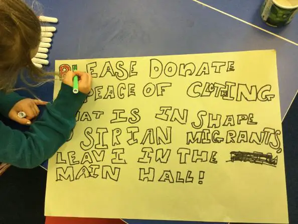 Lynette Nusbacher's daughter prepares a poster for a program intended to provide clothing aid for Syrian refugees