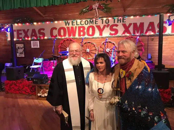 Michael Martin Murphey and his spouse Cynthia Tune pose with the Methodist minister after the wedding.