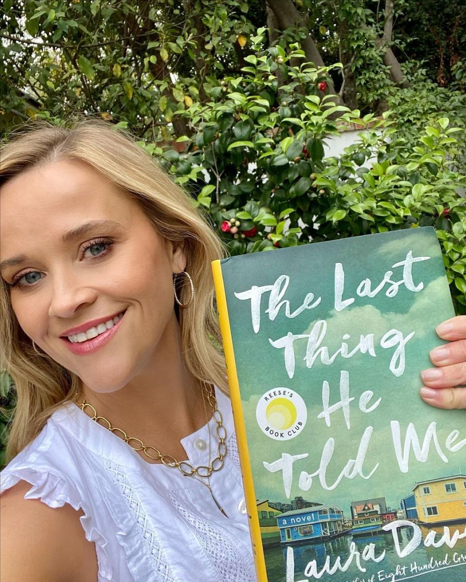 Reese Witherspoon posing with Laura Dave's Book, Last Thing He Told Me