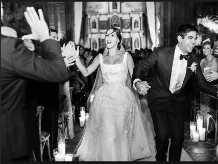 Adria Arjona walking down the aisle with her husband Edgardo Canales on her wedding day.